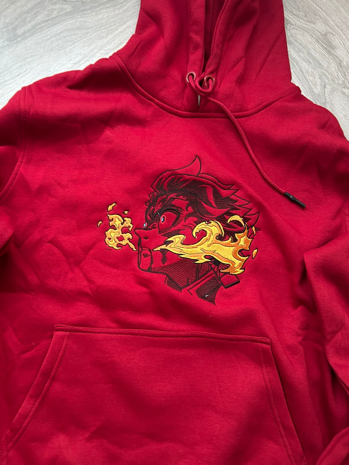 Red hoodie with a dragon design on a light gray background